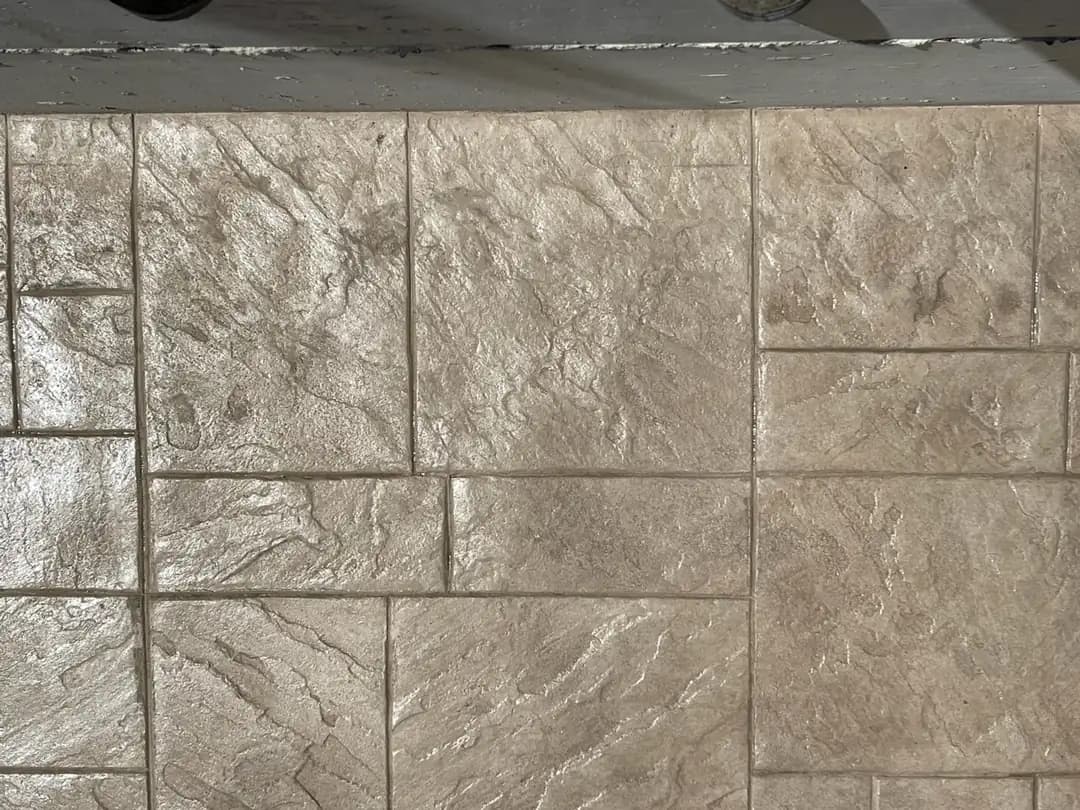 Top-down detail of an ashlar slate stamped concrete pattern with varied rectangular shapes and light gray tones.