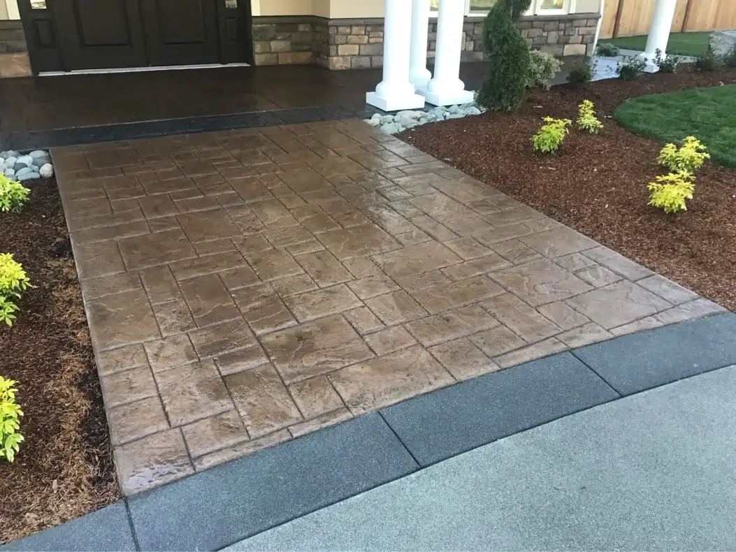 Wide view of a new stamped concrete walkway in Tacoma with an ashlar slate pattern and dark charcoal border.