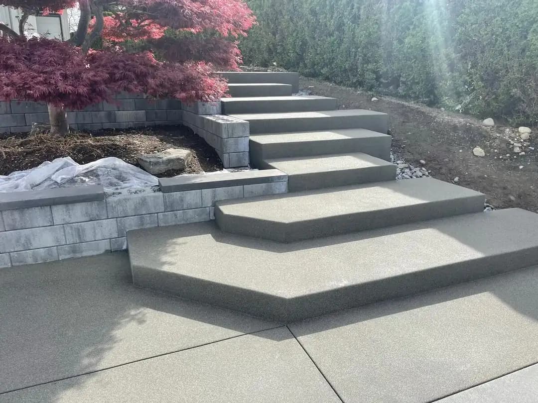 Close-up of the angular landing and lower steps of a custom concrete staircase in Puyallup, WA.