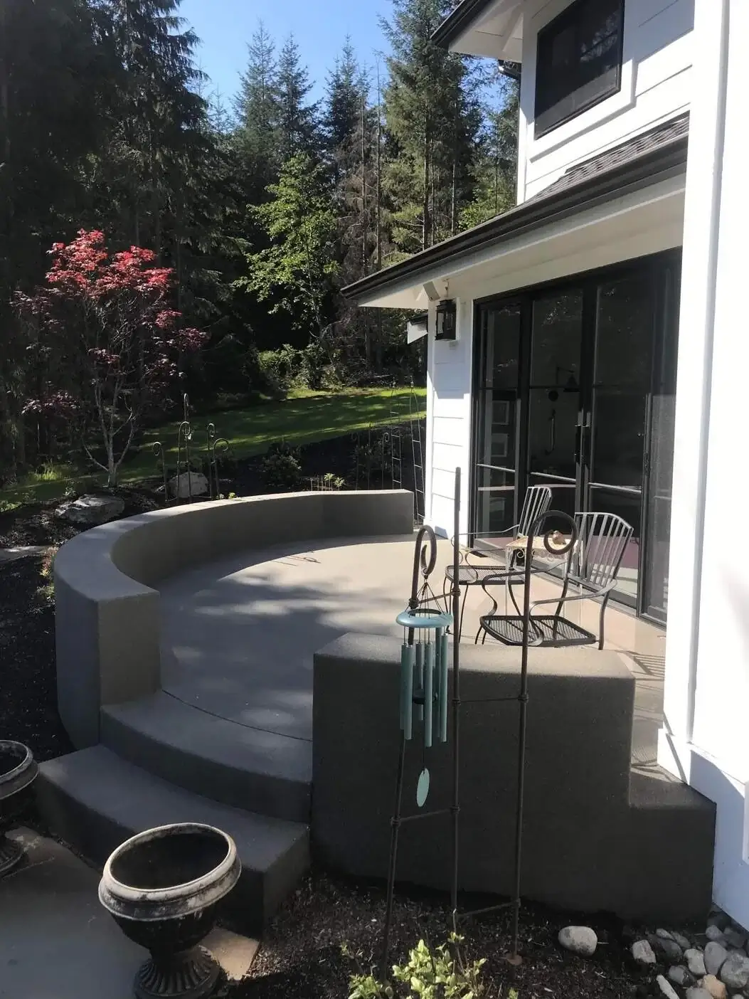 Front view of the curved concrete seat wall and steps, showcasing the consistent exposed aggregate texture.