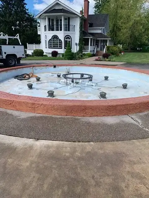 Wide view of a custom stamped concrete water feature with a textured retaining wall in Enumclaw, WA.