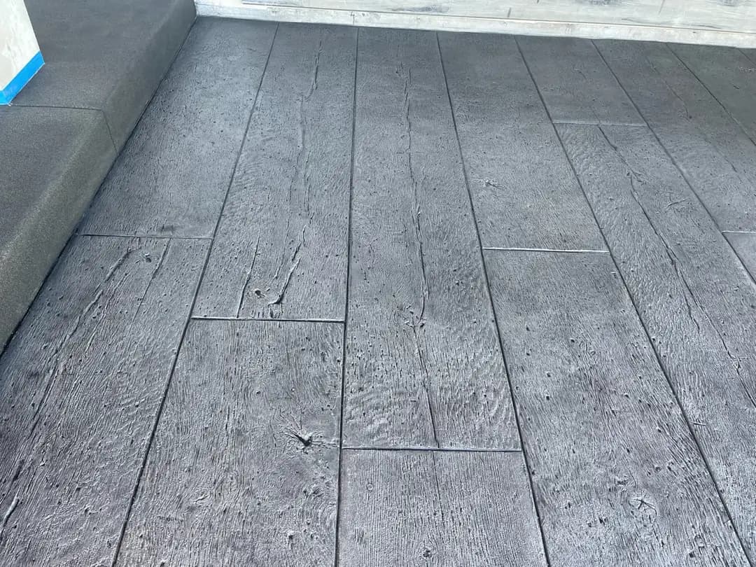 Close-up of the staggered plank layout on a stamped concrete floor, mimicking traditional hardwood flooring.